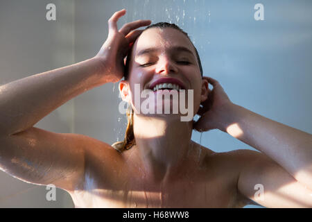 Woman taking a shower in bathroom Stock Photo