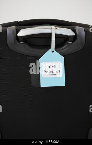 Travel insurance label tied to a suitcase Stock Photo