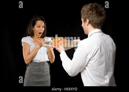 Business woman being given a laptop by a business man Stock Photo
