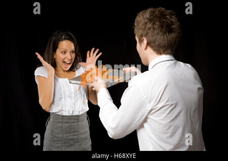 Business woman being given a laptop by a business man Stock Photo