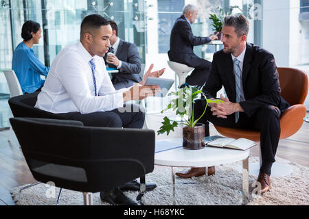 Businessmen having discussion over digital tablet Stock Photo