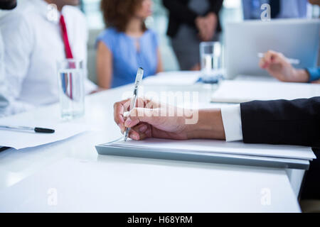 Businessman writing notes in office Stock Photo