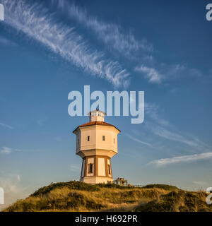 Wasserturm Langeoog. Germany Deutschland.  Langeoog's most famous landmark the water tower, Wasserturm, photographed in the golden hour before sunset.  The direction of the light gives a great sense of the tower's three dimensions.  The light gives a wonderful golden glow to the white water tower. Stock Photo