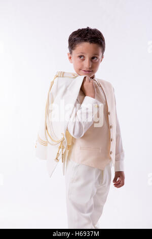 Young First Communion boy with his jacket over his shoulder on white background Stock Photo