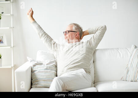 senior man in glasses relaxing on sofa Stock Photo