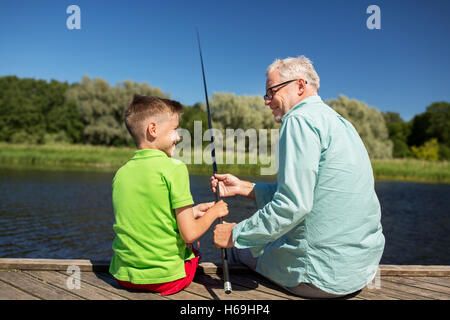 grandfather and grandson fishing on river berth Stock Photo