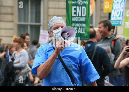 A doctor joins the protest of hundreds of thousands of demonstrators against austerity, as they march together down Whitehall towards the Houses of Parliament. The cuts to public spending has negatively effected the budgets of NHS hospitals and new contracts have forced doctors out in protest against the Health Secretary, Jeremy Hunt. Stock Photo