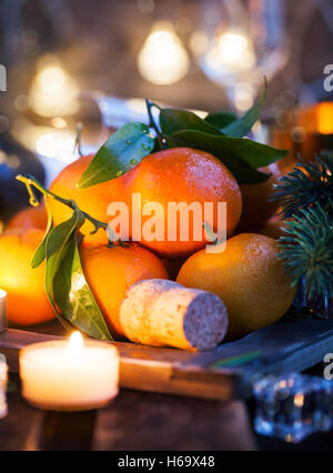 Holiday concept: fresh tangerines, cork, glass, champagne, candles and garlands Stock Photo