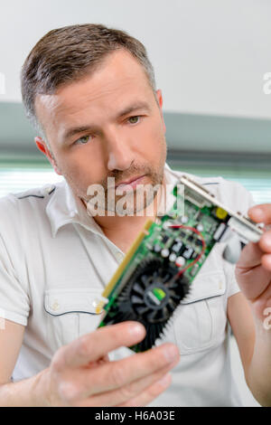 Computer specialist looking at a video card Stock Photo