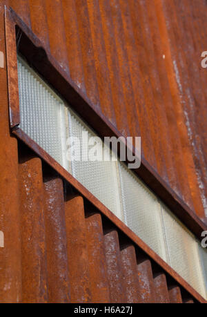 Old, Rusty, Corrugated Metal Wall with Row of Glass Brick Photographed at an Angle from below Stock Photo