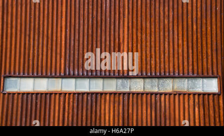 Old Rusty Corrugated Metal Wall with Glass Bricks, Some Cracked,on Downtown Billings Montana Building Stock Photo