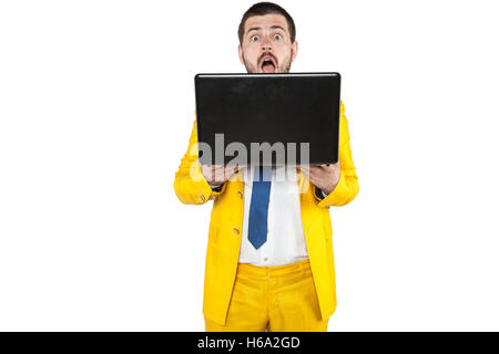 frightened face of a businessman sticking out from behind the computer Stock Photo