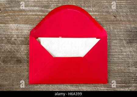 Opened red envelope with blank letter on wooden desk Stock Photo