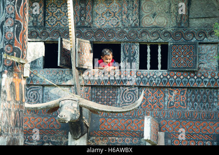 Toraja family pose for camera at the window of Toraja traditional house called Tongkonan at Buntu Pune, North Toraja. Stock Photo