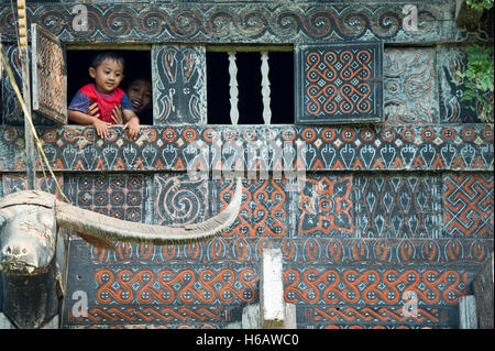 Toraja family pose for camera at the window of Toraja traditional house called Tongkonan at Buntu Pune, North Toraja. Stock Photo