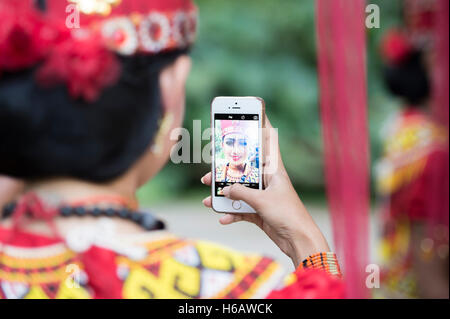 Selfie time for Toraja traditional dancer with colourful traditional costume. The dance called Sanda Oni Stock Photo