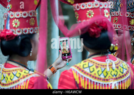 Selfie time for Toraja traditional dancer with colourful traditional costume. The dance called Sanda Oni Stock Photo
