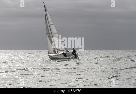 Alone on the ocean, lone yachtsman with horizon in background with yacht and sailor on the Atlantic Ocean off the coast of County Cork, Ireland Stock Photo