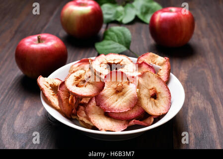 Fruit snack dehydrated apple chips in bowl on wooden table Stock Photo