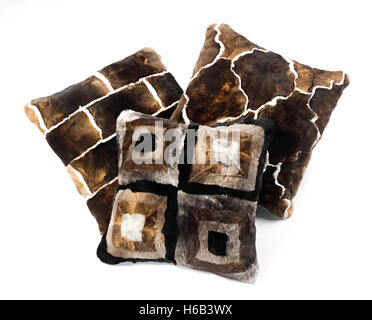Three brown toned fur pillows with different bold geometric designs isolated on white in an interior decor concept Stock Photo