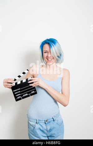 Teen alternative girl smiling and posing on white background with movie clapper board for actress audition Stock Photo