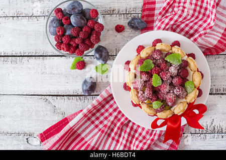 Cake "Charlotte " with raspberries and plums. Top view Stock Photo
