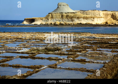 A peaceful bathing coastal resort in Gozo with salt pans in the foreground Stock Photo
