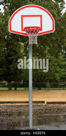 New basketball pole, hoop, backboard, and net on a rainy day. Stock Photo