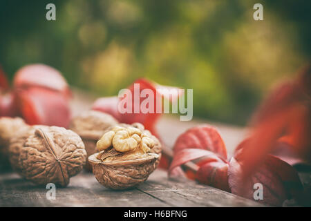 Walnuts on wooden table. Green blurry background with plenty of copy space Stock Photo
