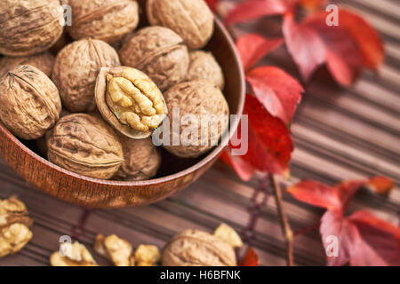 Walnuts in wooden bowl on wooden background Stock Photo