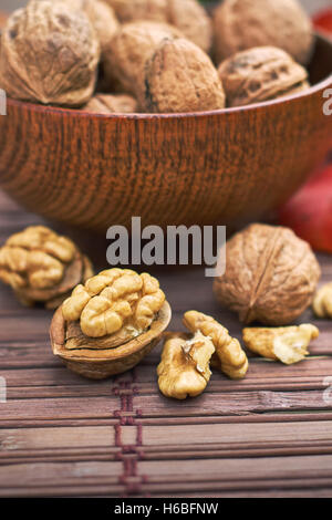 Walnuts in wooden bowl on wooden background Stock Photo