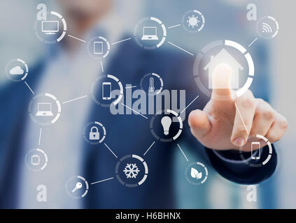 Smart home automation interface with user in background touching button to control house equipments Stock Photo