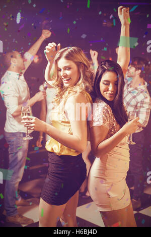 Composite image of happy friends dancing while having drink Stock Photo