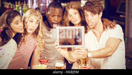 Composite image of friends taking selfie with tablet Stock Photo