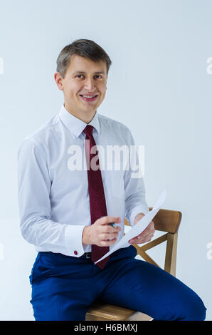 A men in a white shirt boxing smiling standing sitting squatting and shows his straight Stock Photo