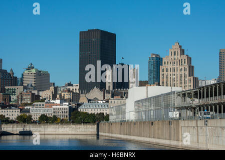Canada, Quebec, Montreal. Old Port area city skyline view from St. Lawrence River. New cruise pier with Notre-Dame Basilica. Stock Photo