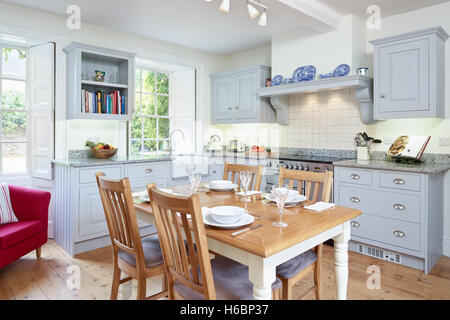 A contemporary, country kitchen incorporating a range cooker, hood & solid wood work surfaces. Gloucestershire, UK Stock Photo