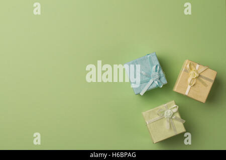 horizontal top view of colored gift boxes on minimal green background paper textures Stock Photo