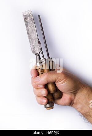 Front view of strong man hand holding tightly a set of old working tools with wooden handles isolated on white background Stock Photo