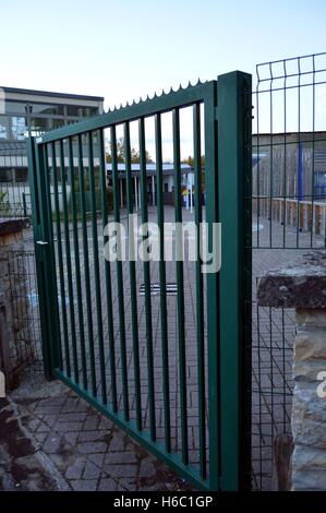 Metal railing of green color which closes enters him of a school Stock Photo