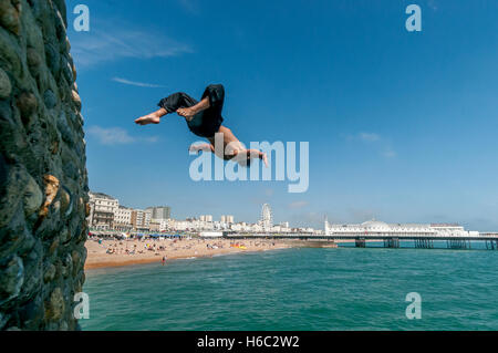 Boy diving into the sea on Brighton beach Stock Photo