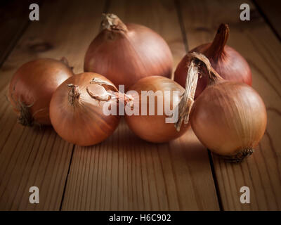 Onions lying on a wooden table in the background Stock Photo