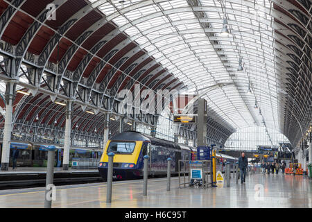 Nearly empty concourse and platform at Paddington station in London. Inter city train and a few commuters under the glass arch Stock Photo