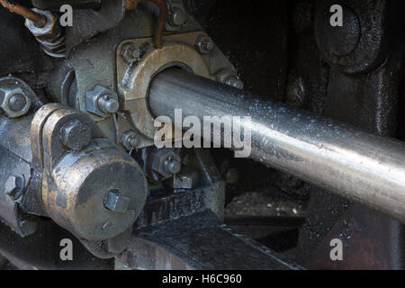Heavy metal machinery. Piston on an old steam train. Oily closeup of the moving parts. Stock Photo