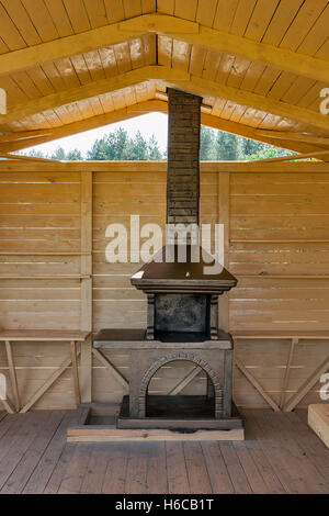 Newly built stone concrete grill placed in a wooden pavilion Stock Photo