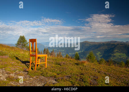 Old wooden chair on the top in Gerlitzen Apls in Austria.View of the mountains in Slovenia. Stock Photo