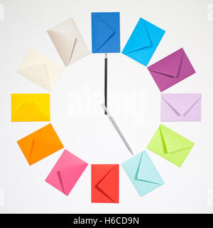 Twelve envelopes isolated on white background. Clock of colored envelopes for Christmas mailing. Stock Photo