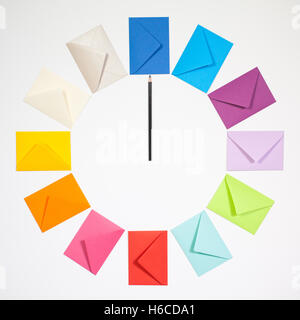 Twelve envelopes isolated on white background. Clock of colored envelopes for Christmas mailing. Stock Photo