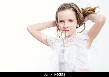 Close up beauty portrait of attractive child in white dress. Stock Photo