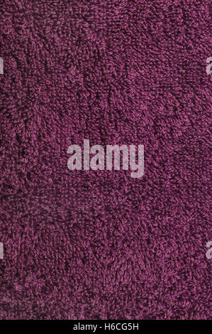 Bath towel in deep pink crimson raspberry wine red, natural Turkish plush terry cloth textured fabric macro background closeup large detailed vertical Stock Photo